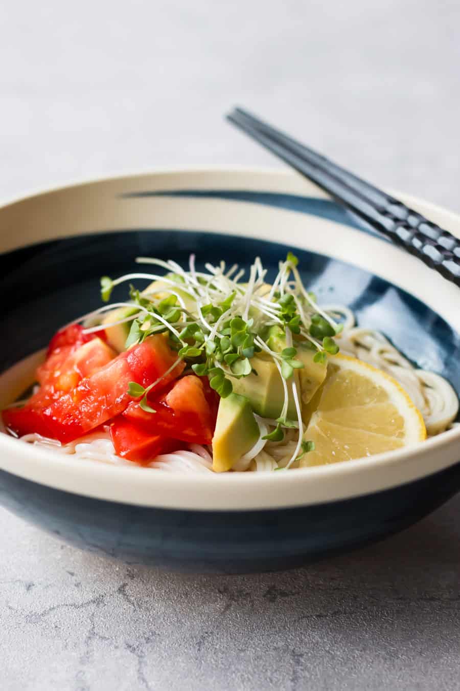 Cold somen noodles with avocado and tomato served in a bowl.